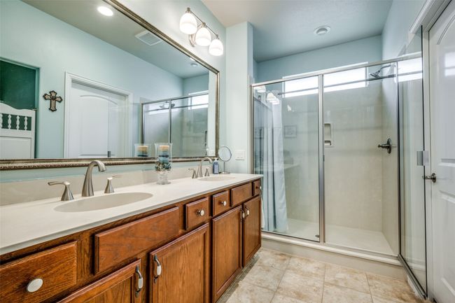 Full bathroom featuring double vanity, a shower stall, and tile patterned floors | Image 9