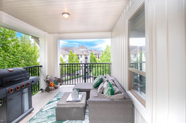 Balcony with an outdoor hangout area, a grill, and a residential view | Image 13