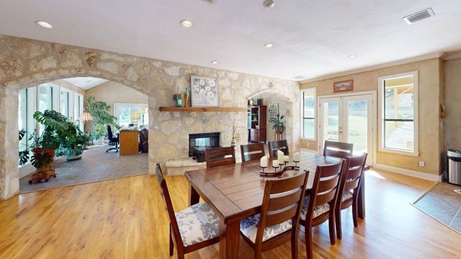 Dining space featuring wood floors, see-through fireplace, arched walkways. | Image 9