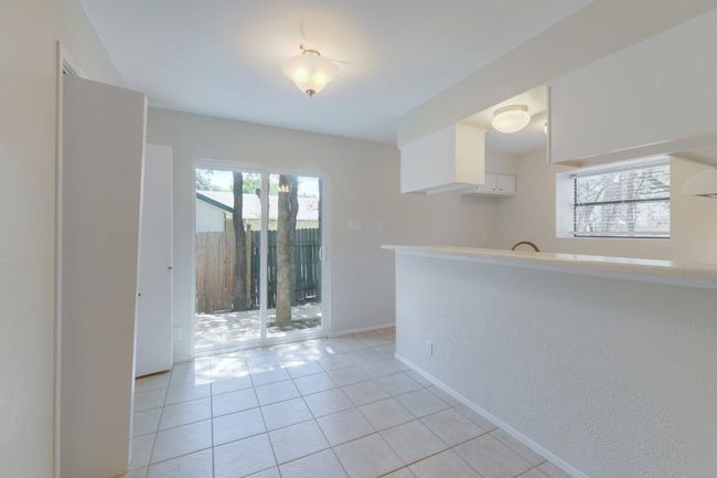 Kitchen with white cabinets, light tile patterned floors, baseboards, and light countertops | Image 8