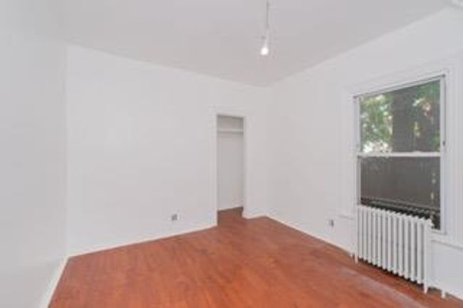 Unfurnished room featuring radiator and wood finished floors | Image 28
