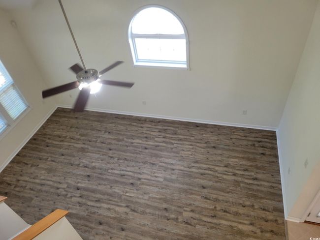 Empty room with a ceiling fan and wood finished floors | Image 15