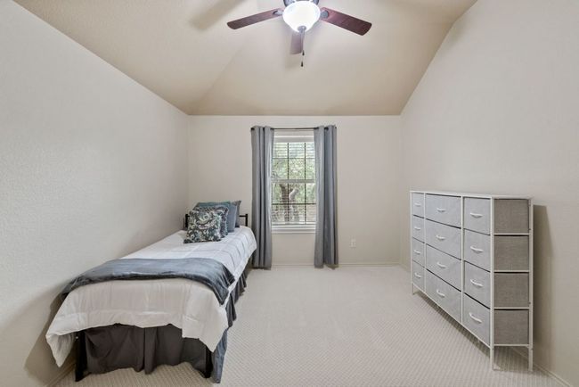 Bedroom featuring lofted ceiling, light colored carpet, and ceiling fan | Image 26