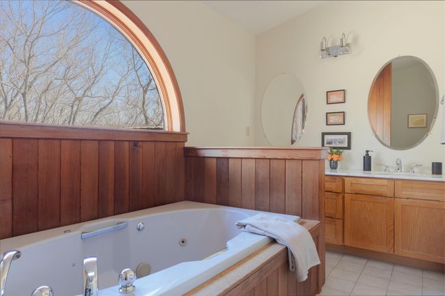 Bathroom featuring tile patterned floors, vanity, and a jetted tub | Image 26