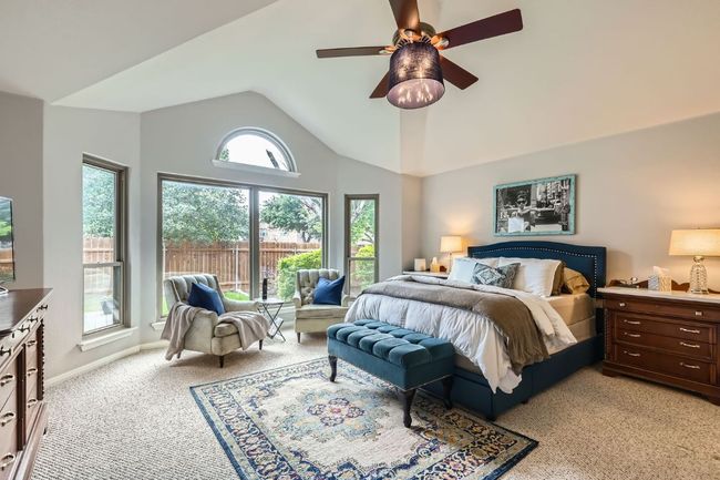 Bedroom with light colored carpet, lofted ceiling, and a ceiling fan | Image 11