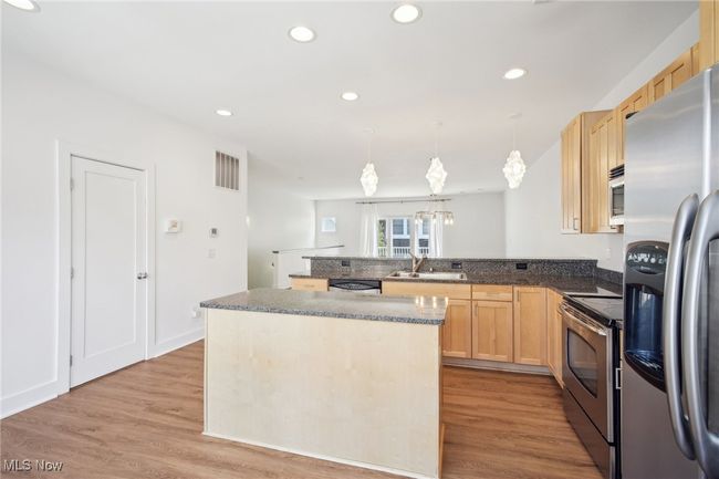 Kitchen featuring a sink, a peninsula, light brown cabinets, and stainless steel appliances | Image 6