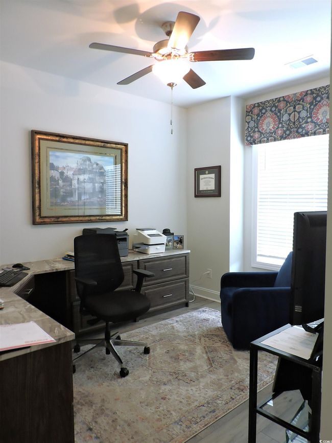 Office space featuring a ceiling fan, wood finished floors, and baseboards | Image 25