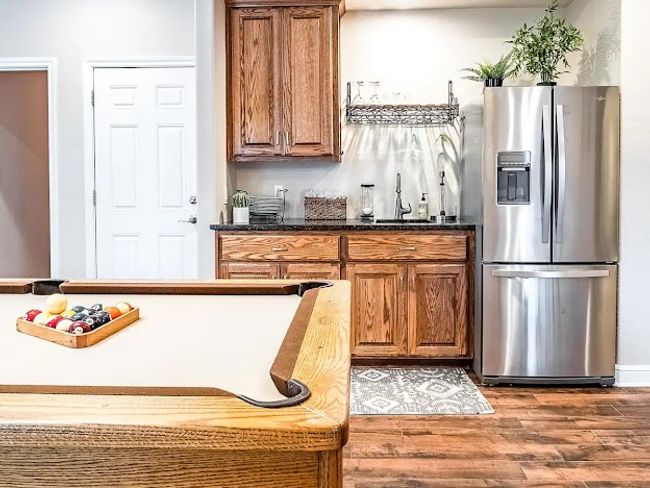 Kitchen with a sink, brown cabinetry, stainless steel refrigerator with ice dispenser, and wood finished floors | Image 6