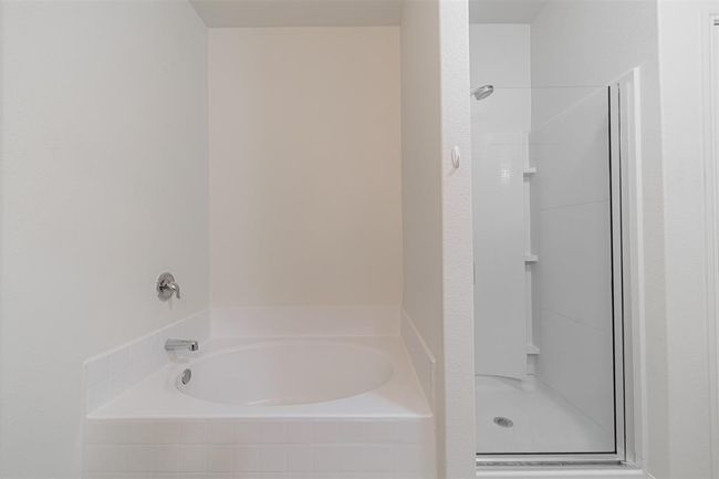 Primary bath features a garden tub and separate shower. | Image 17