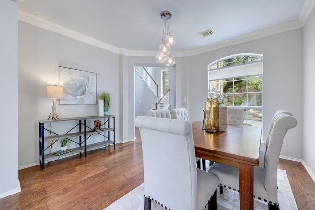 Dining room with crown molding, wood finished floors, stairway, and baseboards | Image 6