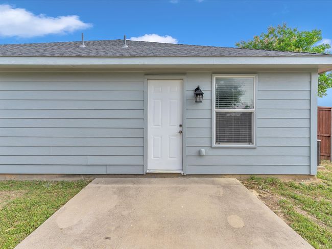 Doorway to property with a patio, fence, and roof with shingles | Image 26