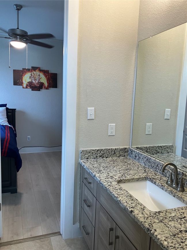 Bathroom featuring vanity, a ceiling fan, wood finished floors, baseboards, and a textured wall | Image 21
