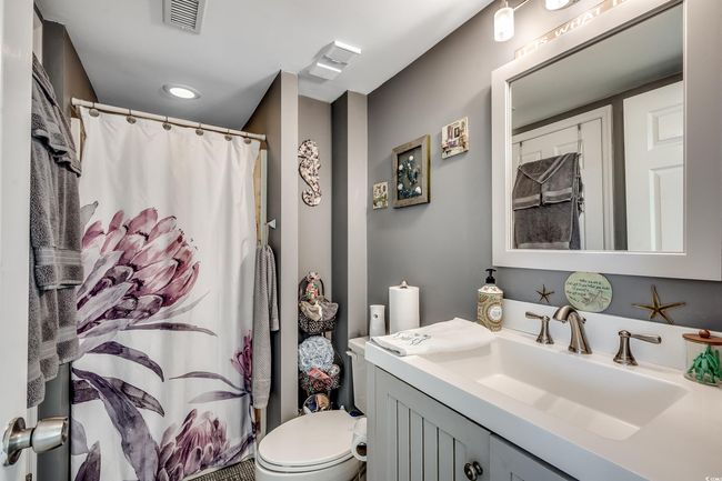 Bathroom with toilet, vanity, a shower with shower curtain, and recessed lighting | Image 12