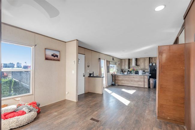 Kitchen with recessed lighting, dark wood-style floors, visible vents, and wall chimney exhaust hood | Image 18