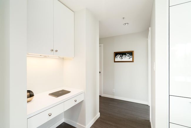 Kitchen with dark wood-style floors, light countertops, white cabinetry, and baseboards | Image 17