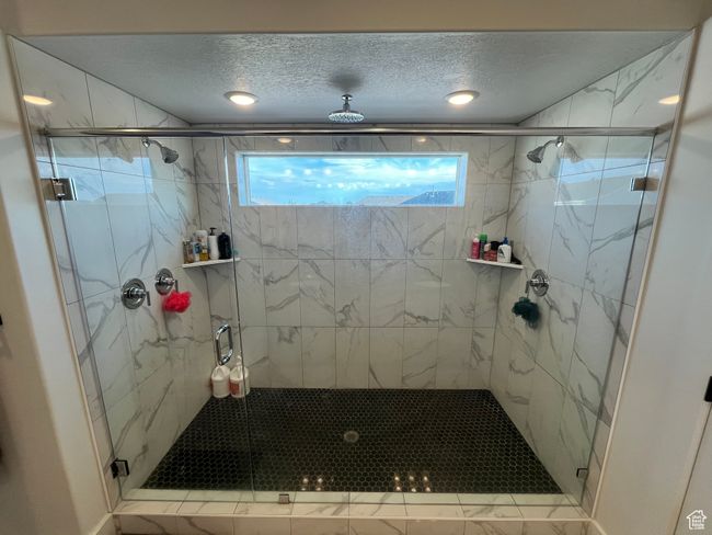 Full bathroom with healthy amount of natural light, a marble finish shower, and a textured ceiling | Image 16