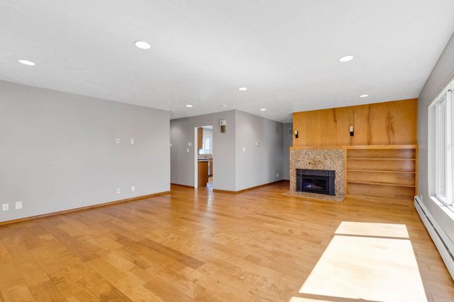 Details featuring a fireplace, wood finished floors, a baseboard heating unit, and baseboards | Image 4