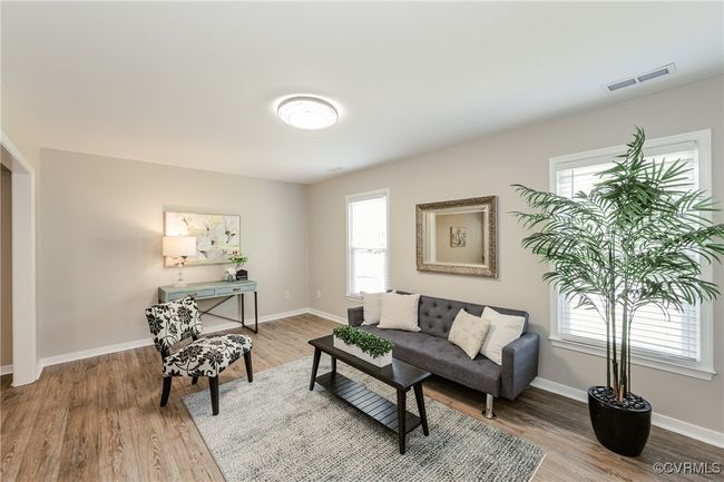 Living area featuring wood finished floors, visible vents, and a wealth of natural light | Image 14