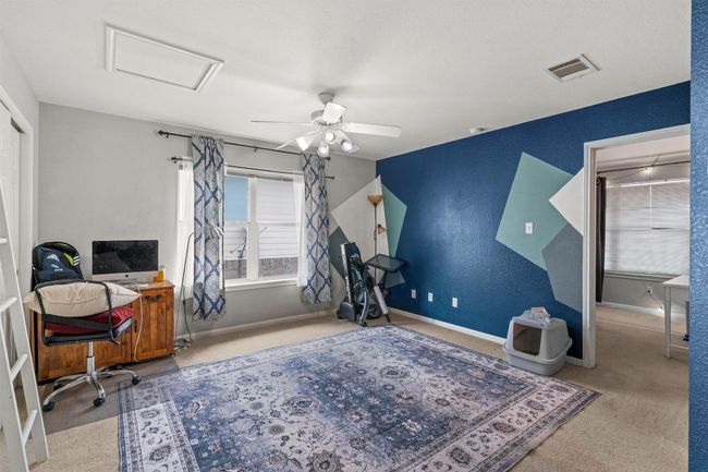 Carpeted home office with attic access, baseboards, visible vents, and ceiling fan | Image 15