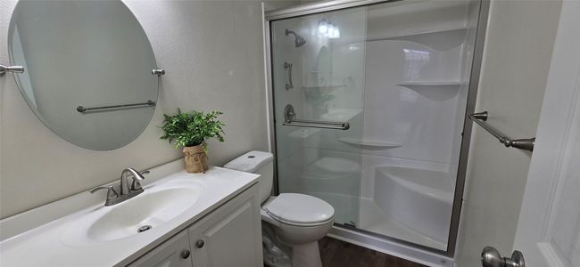 Bathroom featuring a shower stall, vanity, and wood finished floors | Image 10