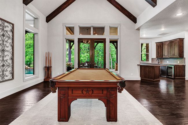 The game room flows to the professional wet bar and the media room. All with lush green views of the the forest. | Image 22