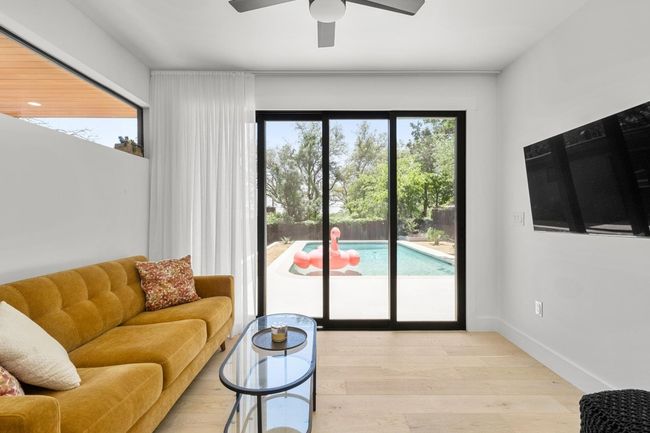 Living room featuring light wood-style flooring and ceiling fan | Image 34