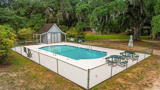 Community pool featuring view of wooded area | Image 27