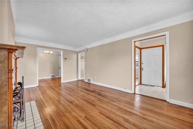 Unfurnished living room with visible vents, a chandelier, and wood-type flooring | Image 27