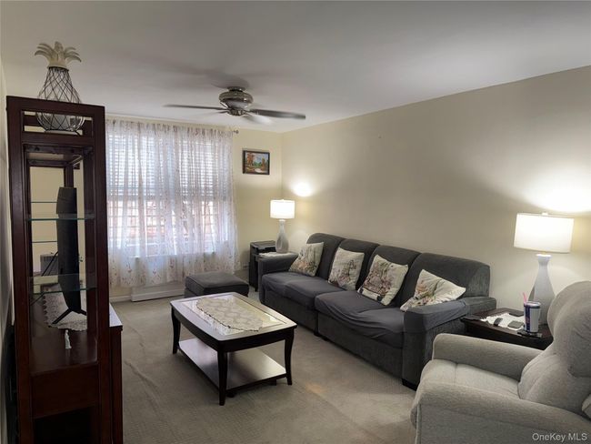 Living area with carpet flooring and a ceiling fan | Image 5