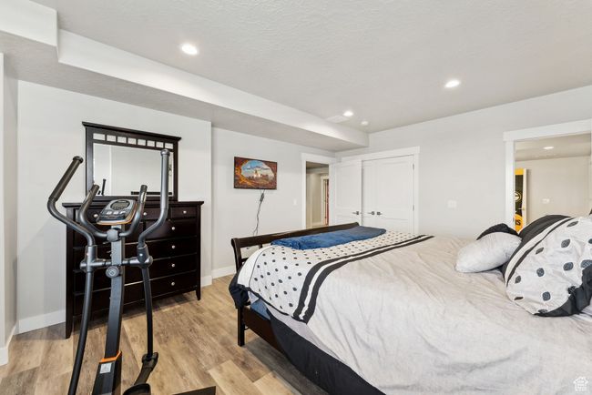 Bedroom with light wood finished floors, a closet, recessed lighting, and baseboards | Image 24