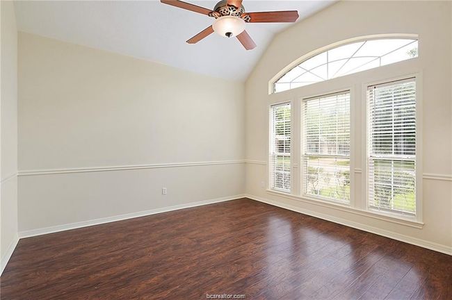 Unfurnished room featuring dark wood-style floors, a ceiling fan, baseboards, and high vaulted ceiling | Image 4