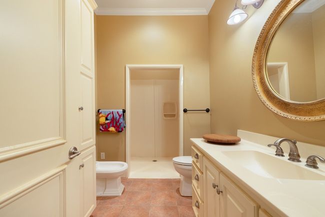 Full bathroom with tile patterned flooring, toilet, vanity, ornamental molding, and a stall shower | Image 23