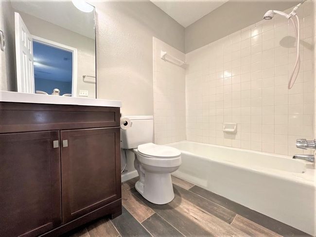 Bathroom featuring wood finished floors, toilet, bathtub / shower combination, and vanity | Image 12