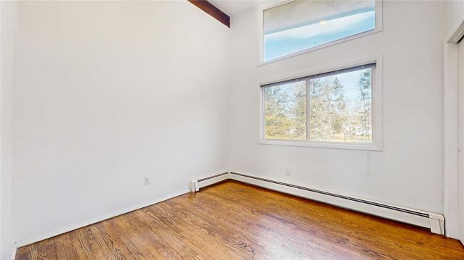 Spare room with wood finished floors, baseboards, and a baseboard radiator | Image 19