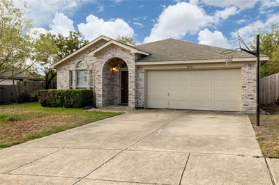 Ranch-style house featuring a garage and a front yard | Image 2