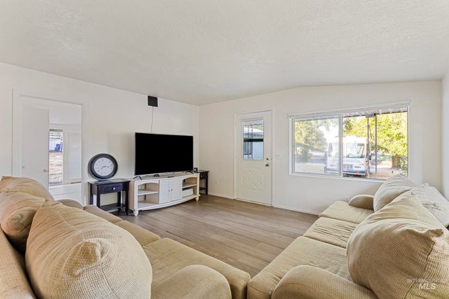Living room with wood finished floors and a textured ceiling | Image 13