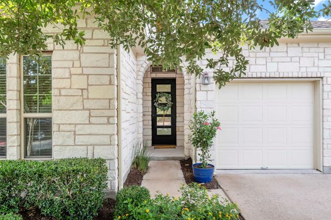 Entrance to property with a garage and stone siding | Image 4
