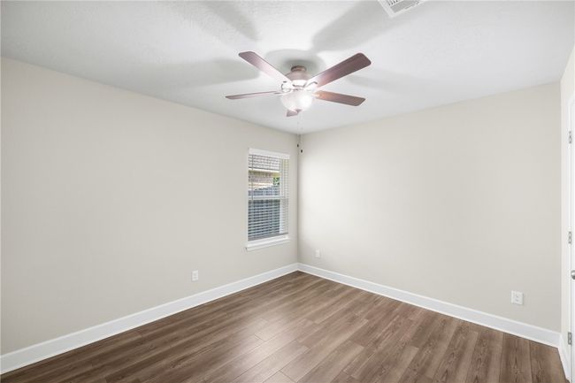 Empty room featuring dark wood-style floors, a ceiling fan, and baseboards | Image 22