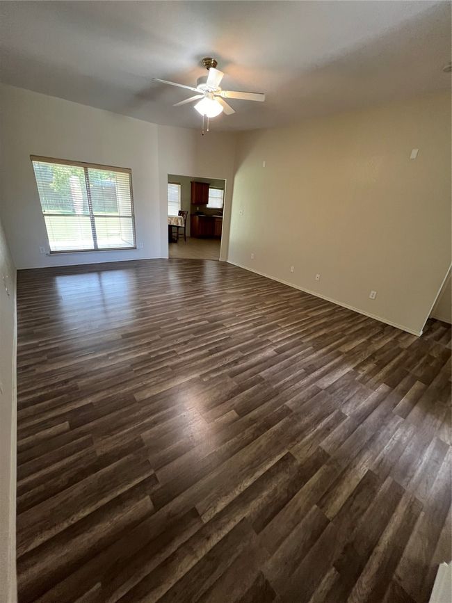 Unfurnished living room with dark wood-style floors and ceiling fan | Image 37