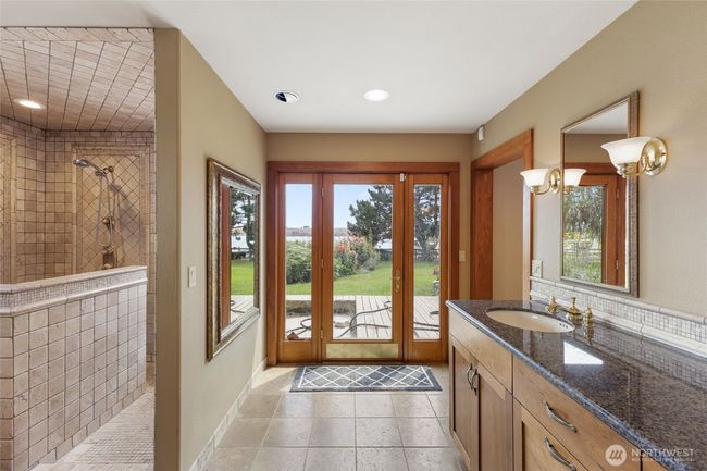Luxury primary bathroom with heated travertine flooring. | Image 18
