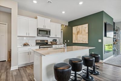 (Picture of a model home, actual features will vary) The stunning kitchen features a large center island quartz countertops, LVP floors, stainless appliances and more. | Image 3