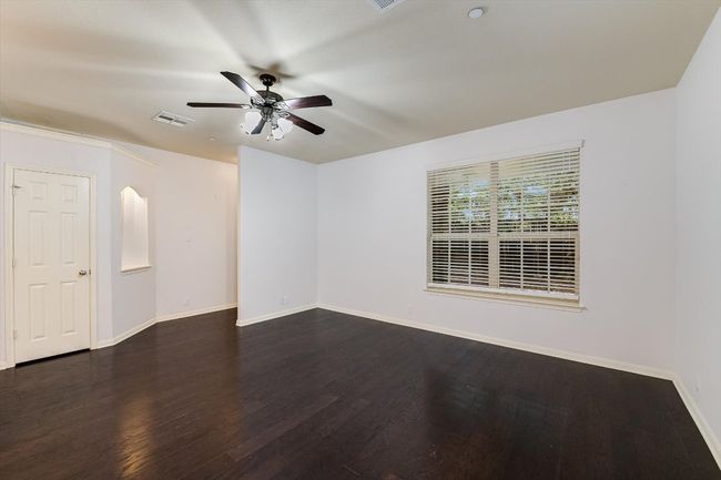 Spare room featuring ceiling fan, dark wood-type flooring, and arched walkways | Image 6