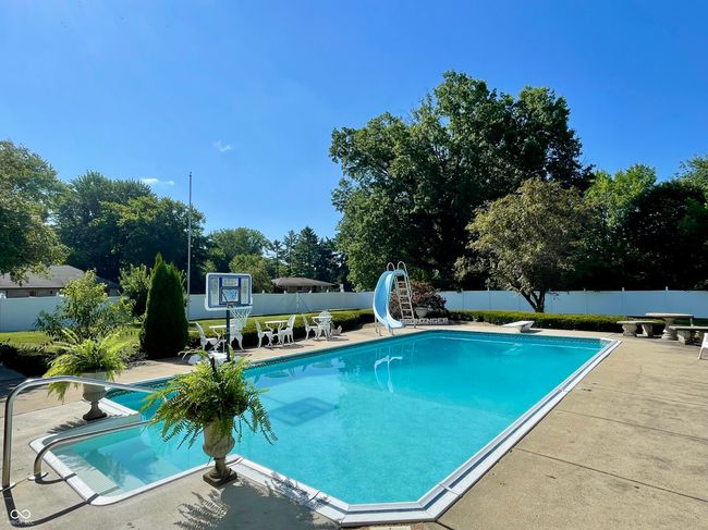 view of pool with a water slide, a fenced backyard, a patio area, and a diving board | Image 13