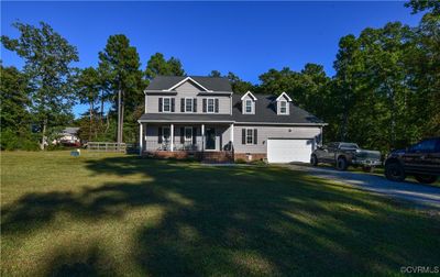 View of front of property with a porch, a front yard, and a garage | Image 2