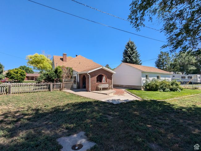 Back of property with a lawn, a patio, fence, brick siding, and a chimney | Image 25