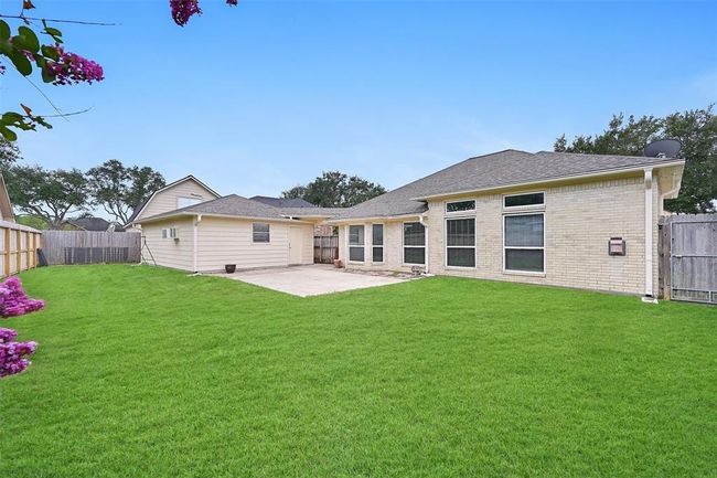 Spacious backyard with a recently replaced fence, extended patio space, and a detached garage—ideal for outdoor entertaining or future customization. | Image 22