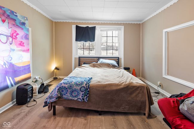 bedroom with wood finished floors, baseboards, and ornamental molding | Image 8