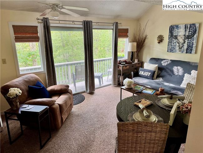 Open, light and bright living room including a comfortable queen futon & super cozy recliner to relax and hear Flattop Creek flowing below. | Image 11