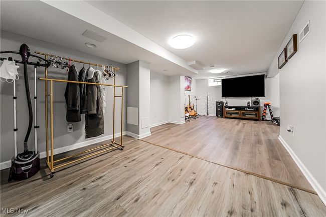 Below grade area with wood finished floors, baseboards, and visible vents | Image 32