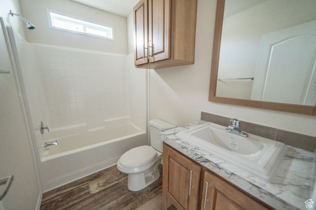 Full bath featuring shower / bathing tub combination, wood finished floors, vanity, and toilet | Image 51